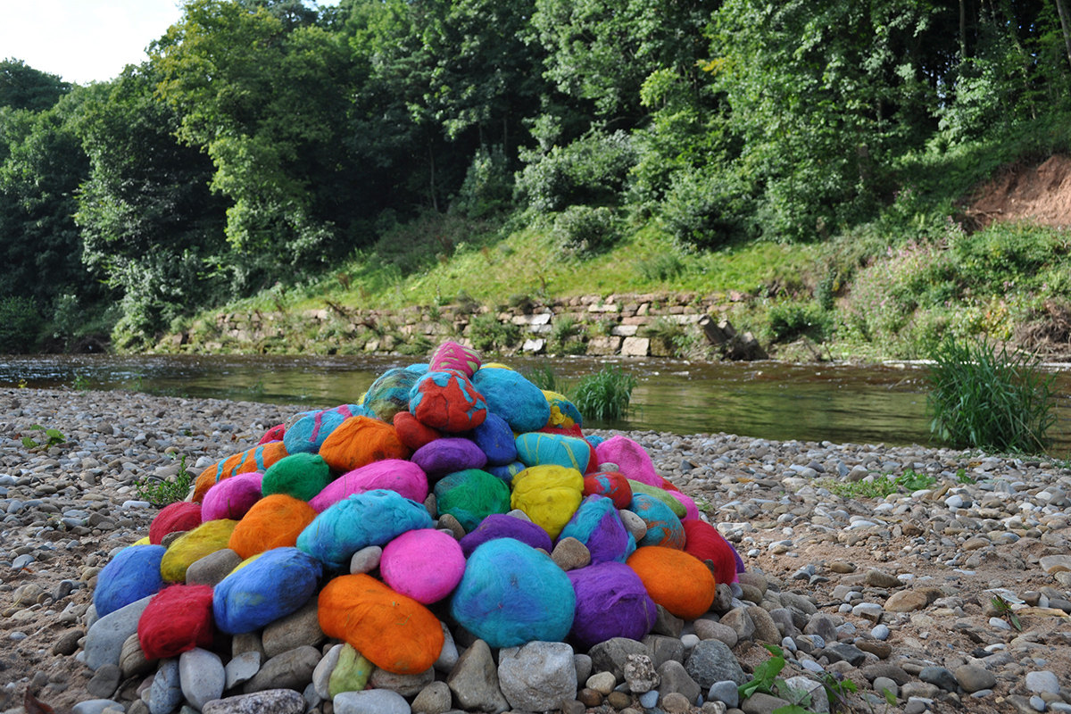Pebbles covered in felt by the river