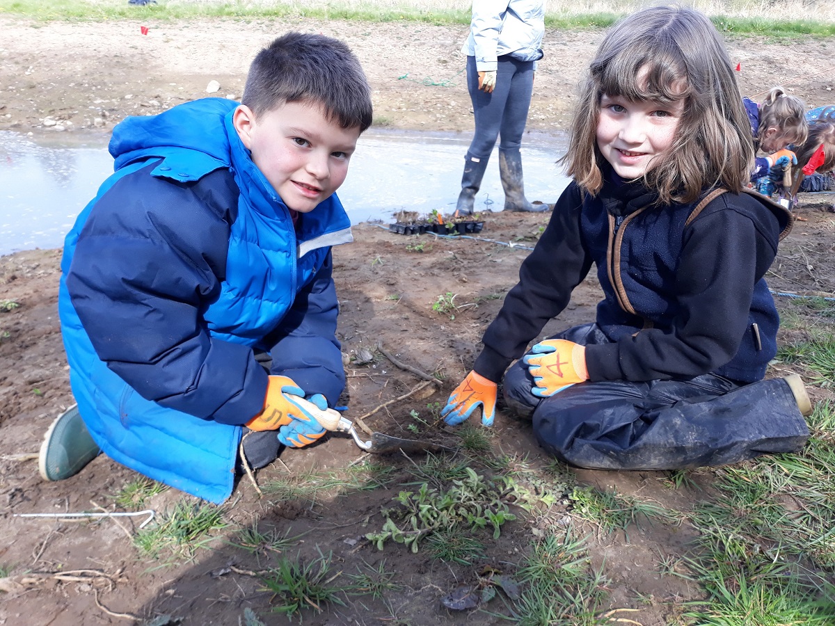 2 crosby Ravensworth Primary school pupils planting a wildflower plug together