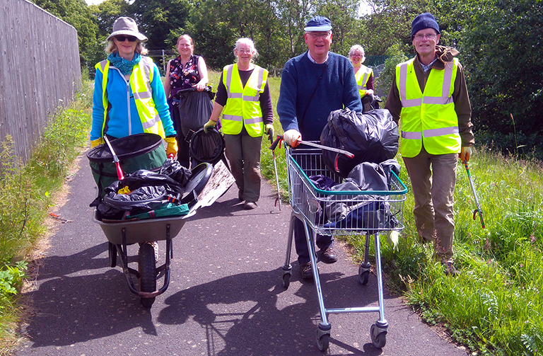 People pushing wheelbarrows full of rubbish