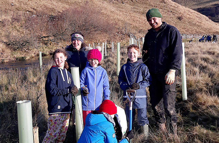 Children planting trees by the river