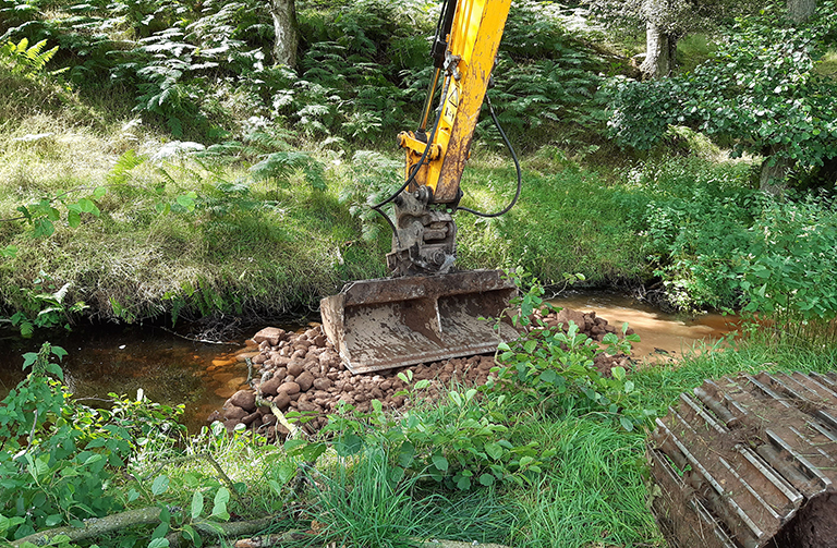 Digger creating a point bar in the river