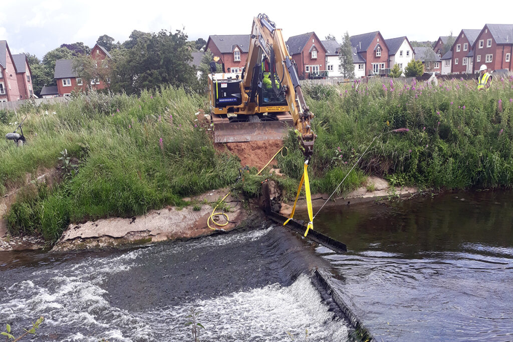 Digger removing a weir