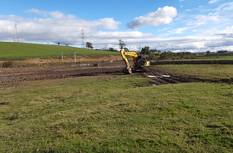 Digger cutting a new river channel