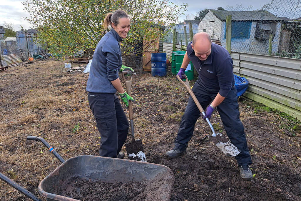 Two people digging the ground using sapdes
