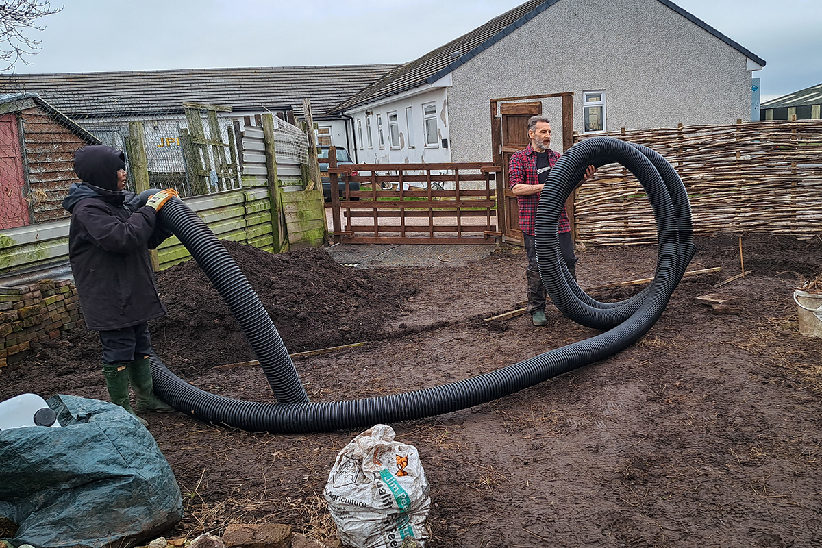 volunteers with a huge, curling length of plastic tubing