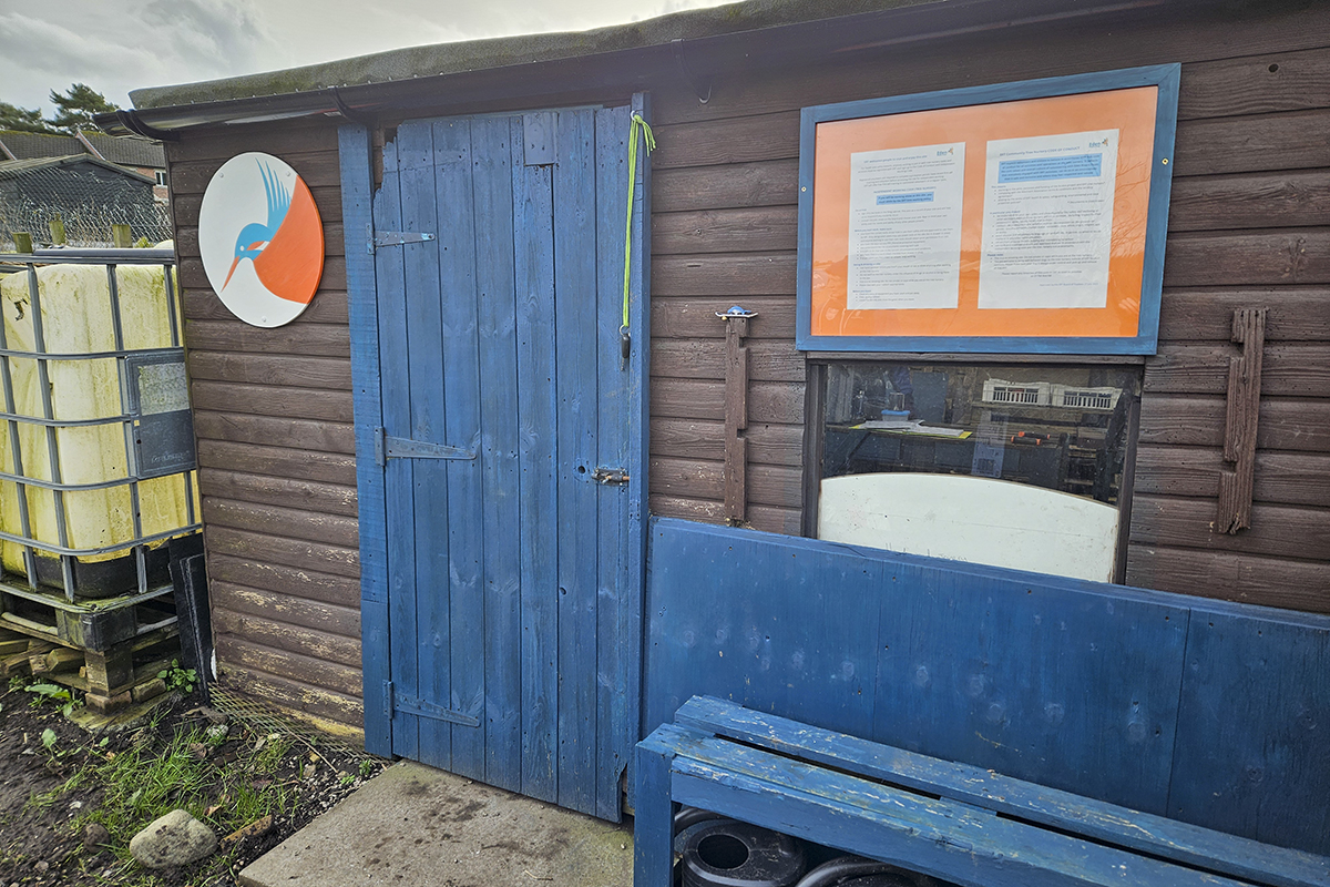 The nursery shed - with ERT blue door, bench and a beautiful hand painted circle with ERT's kingfisher logo inside it.